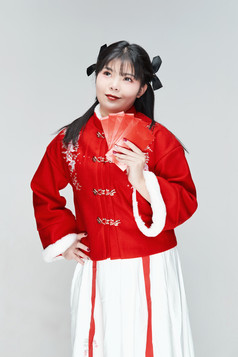 白色背景下身穿喜庆汉服手拿红包的可爱少女