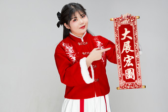 手持<strong>春联</strong>身穿喜庆汉服的可爱少女