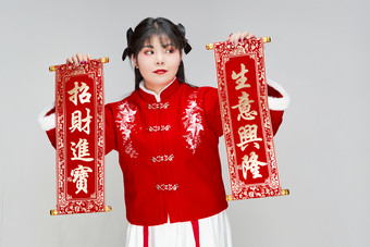 手持<strong>春联</strong>身穿喜庆汉服的可爱少女