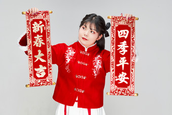 手持<strong>春联</strong>身穿喜庆汉服的可爱少女