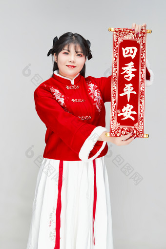 手持<strong>春联</strong>身穿喜庆汉服的可爱少女