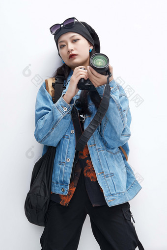 <strong>出门旅行</strong>手上拿着单反相机的美丽亚洲女孩