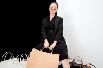 黑白色背景下的手提购物袋的时尚亚洲少女