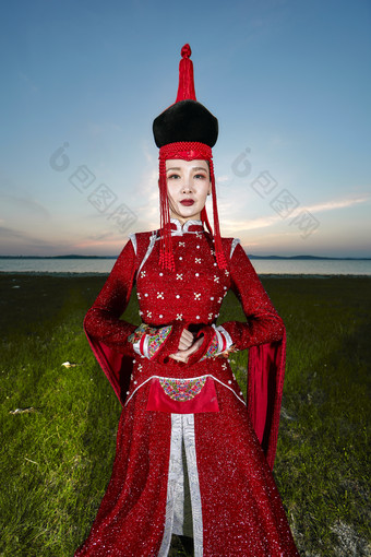 晚霞的草原湖畔穿<strong>蒙古族</strong>传统服饰的年轻女性