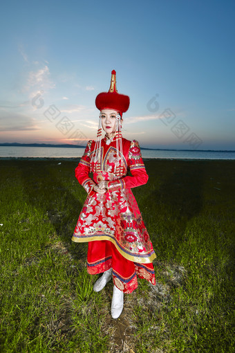 晚霞的草原湖畔穿蒙古族<strong>传统服饰</strong>的年轻女性