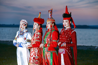 晚霞的<strong>草原</strong>湖畔穿蒙古族传统服饰的年轻女性