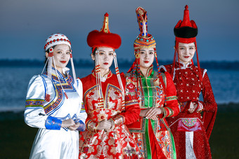 晚霞的草原<strong>湖畔</strong>穿蒙古族传统服饰的年轻女性