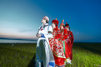 晚霞的草原湖畔穿蒙古族传统服饰的年轻女性