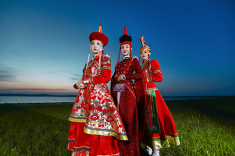 晚霞的草原<strong>湖畔</strong>穿蒙古族传统服饰的年轻女性
