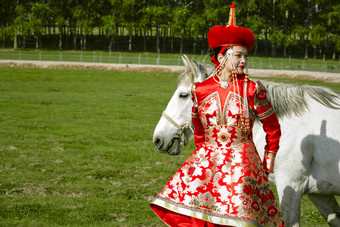 草原上穿着蒙古族传统服饰的亚洲年轻美<strong>少女</strong>