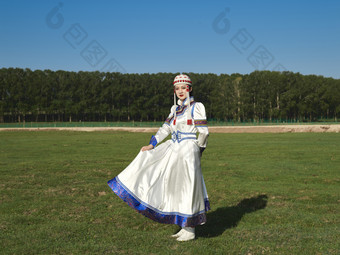 草原上穿着蒙古族传统服饰的亚洲年轻美少女