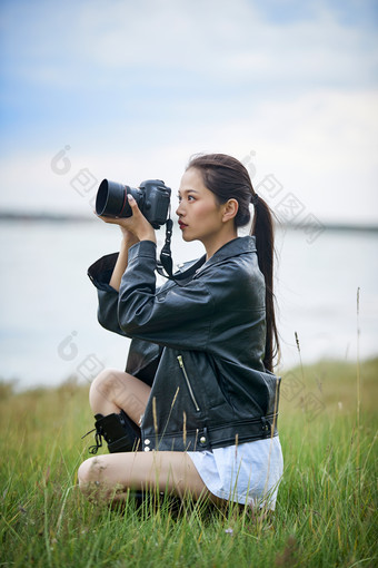 户外湖畔进行拍摄的亚洲青年女性摄影师