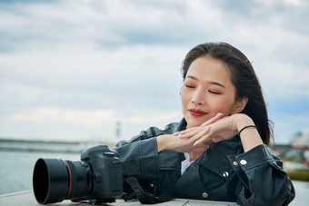 户外湖畔进行拍摄的亚洲青年女性摄影师