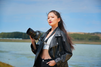 户外湖畔进行拍摄的亚洲青年女性摄影师