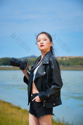 户外<strong>湖畔</strong>进行拍摄的亚洲青年女性<strong>摄影</strong>师