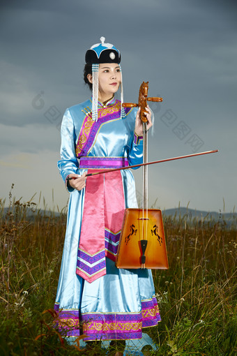 草原上穿蒙古族服饰拉马头琴的蒙族女乐手
