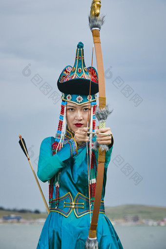 草原湖畔身穿蒙古族饰手持<strong>弓箭</strong>的蒙族少女