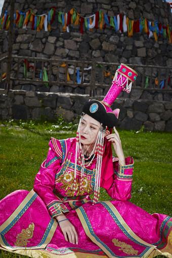草原上敖包前身穿豪华蒙古族服饰的蒙族少女