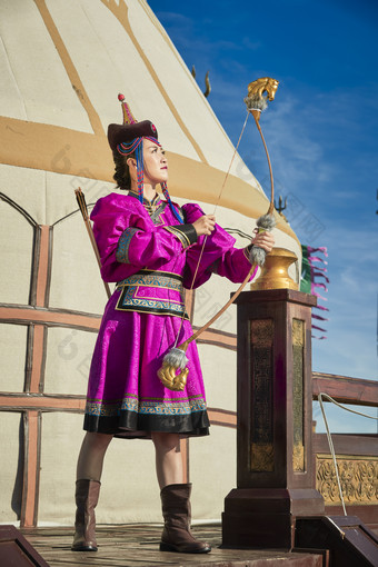 蒙古包前身穿蒙古族饰手持弓箭的蒙族少女