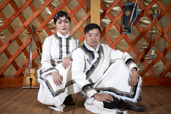 草原上蒙古包里穿蒙古族传统服饰的年轻夫妻