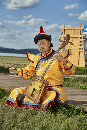 蒙古包前身穿蒙古族<strong>服饰</strong>拉马头琴的男子