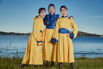 草原上穿着蒙古族传统服饰的年轻蒙族姐妹