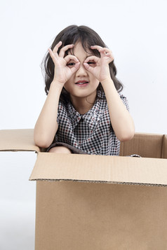 躲在纸箱中玩耍的调皮可爱亚洲小女孩儿童