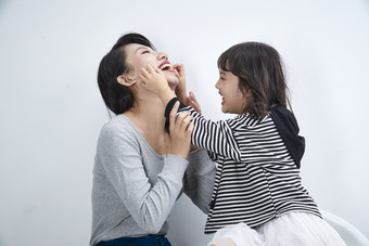 白色背景的美丽妈妈与可爱女儿亲子人像