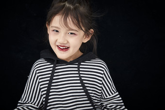 黑色背景的调皮可爱的亚洲小女孩儿童