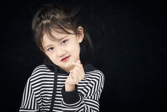 黑色背景的<strong>调皮</strong>可爱的亚洲小女孩儿童