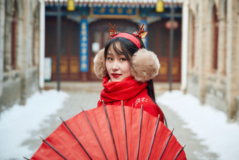 雪后在老城古巷穿着<strong>喜庆</strong>服饰的亚洲少女