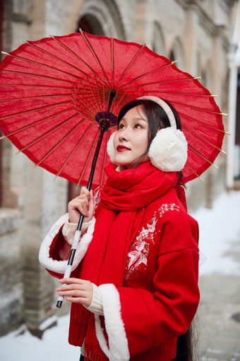 雪后在老城<strong>古巷</strong>穿着喜庆服饰的亚洲少女