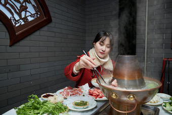 在饭店吃传统<strong>铜锅</strong>涮肉的亚洲少女