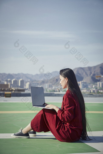 亚洲商务年轻<strong>女性</strong>在楼顶停机坪使用电脑办公