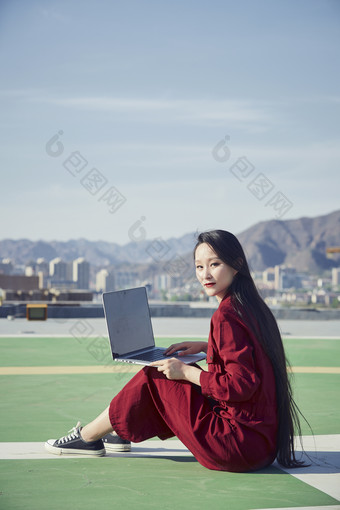 亚洲商务年轻<strong>女性</strong>在楼顶停机坪使用电脑办公