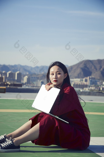 亚洲商务年轻<strong>女性</strong>在楼顶停机坪使用电脑办公