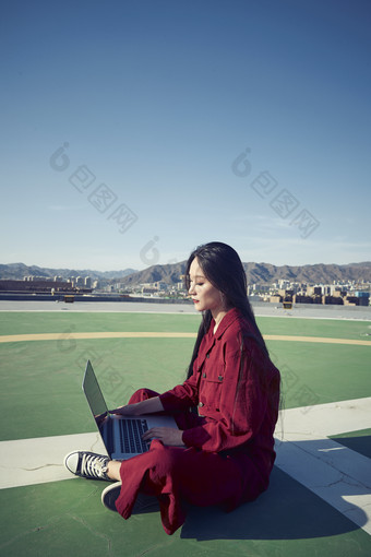 亚洲商务年轻<strong>女性</strong>在楼顶停机坪使用电脑办公