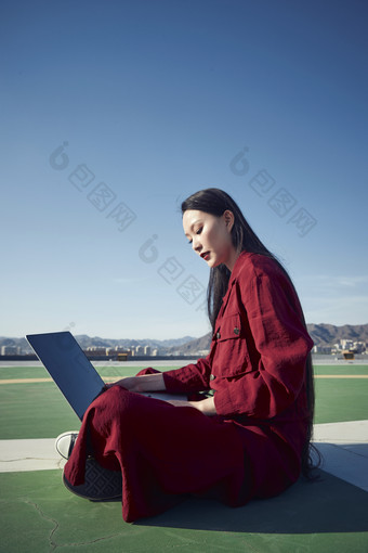 亚洲商务年轻<strong>女性</strong>在楼顶停机坪使用电脑办公