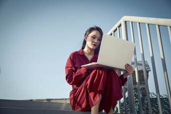 亚洲商务年轻<strong>女性</strong>在楼顶停机坪使用电脑办公