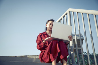 亚洲商务年轻<strong>女性</strong>在楼顶停机坪使用电脑办公