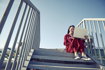 亚洲商务年轻<strong>女性</strong>在楼顶停机坪使用电脑办公