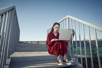 亚洲商务年轻<strong>女性</strong>在楼顶停机坪使用电脑办公