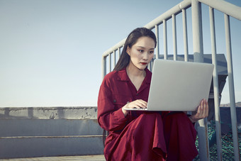 亚洲商务年轻<strong>女性</strong>在楼顶停机坪使用电脑办公