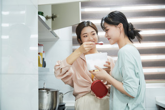 在厨房烹饪美食的亚洲闺蜜少女