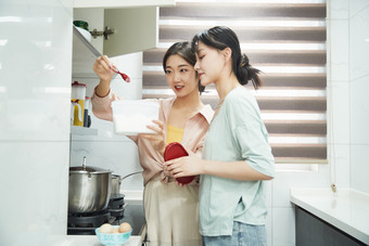 在厨房烹饪美食的亚洲闺蜜少女