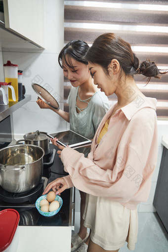 在厨房烹饪美食的亚洲闺蜜少女