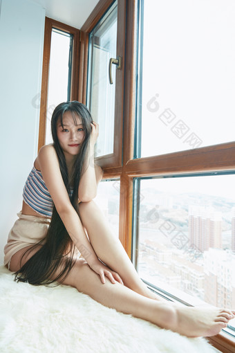 躺在舒适的飘窗上听音乐追剧的亚洲少女