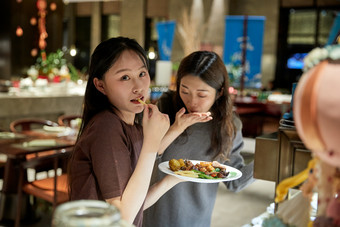 在酒店自助餐厅大吃特吃的亚洲可爱闺蜜少女