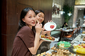 在酒店自助餐厅大吃特吃的亚洲可爱闺蜜少女