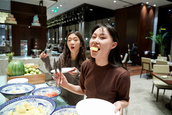 在酒店自助餐厅大吃特吃的亚洲可爱闺蜜少女